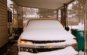 Voiture recouverte de neige sous un CARPORT